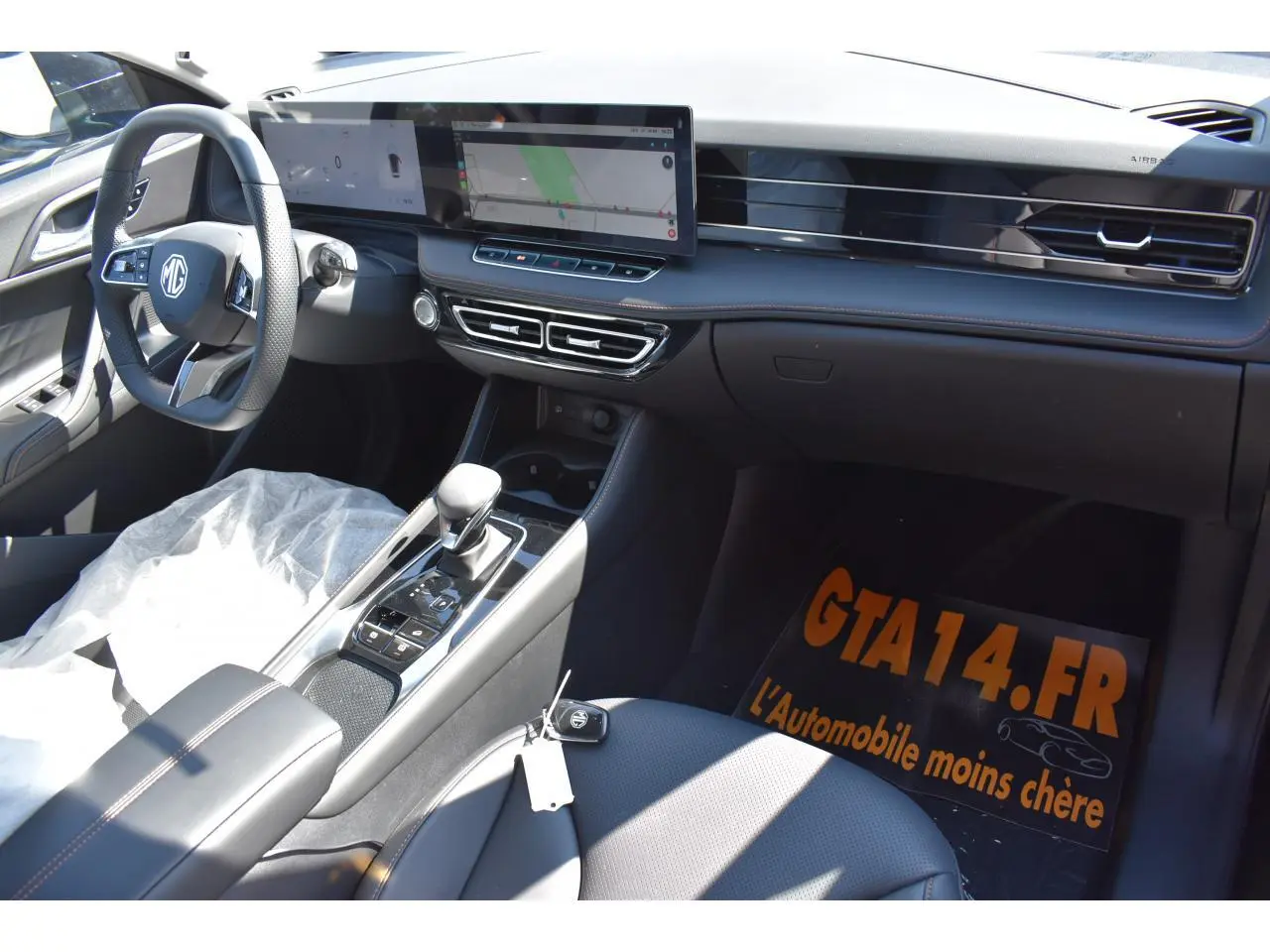 Intérieur du MG Motor EHS 1.5 Hybrid+ 224 ch Luxury 2026, vue côté passager montrant tableau de bord et console centrale noire.