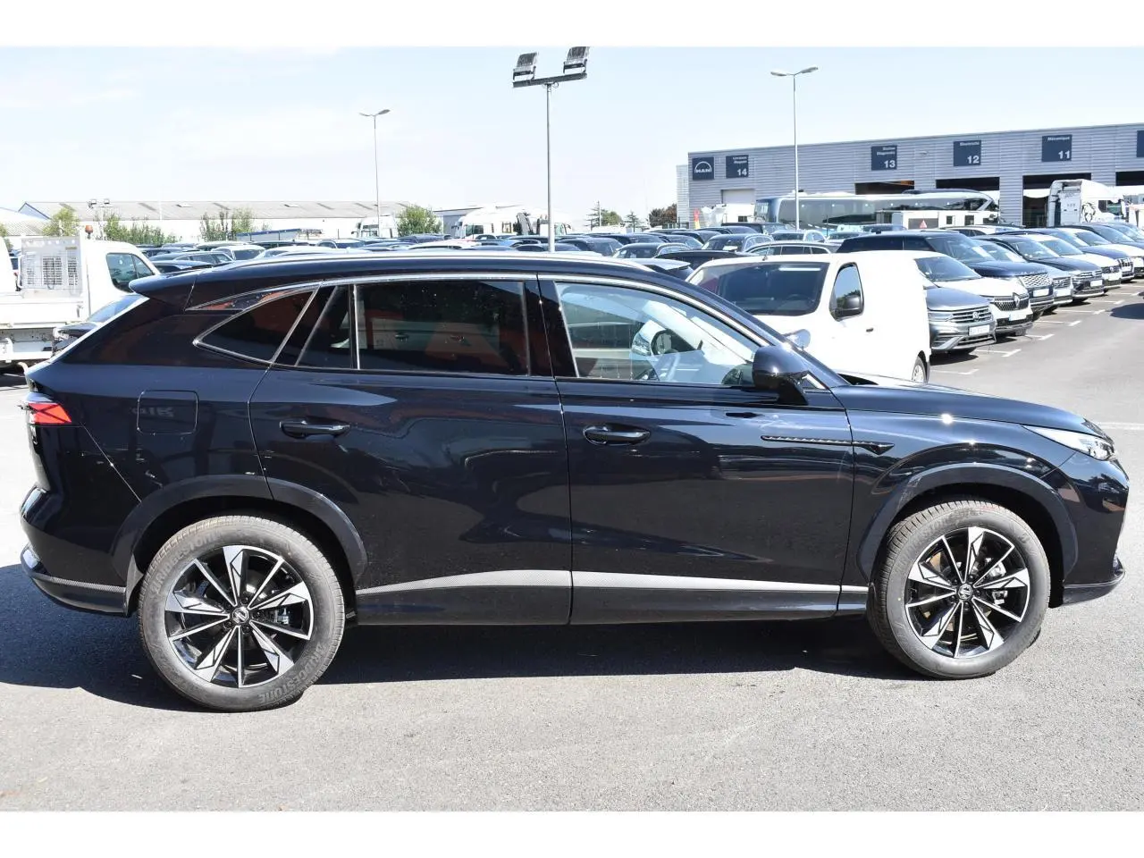 Vue de profil côté gauche du SUV MG EHS noir 2026 avec jantes alliage 19 pouces et vitres surteintées.