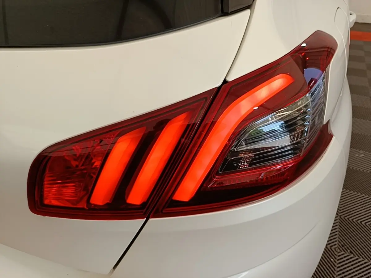 Gros plan sur le feu arrière droit rouge allumé d’une Peugeot 308 blanche, version BlueHDi 130 de 2020.