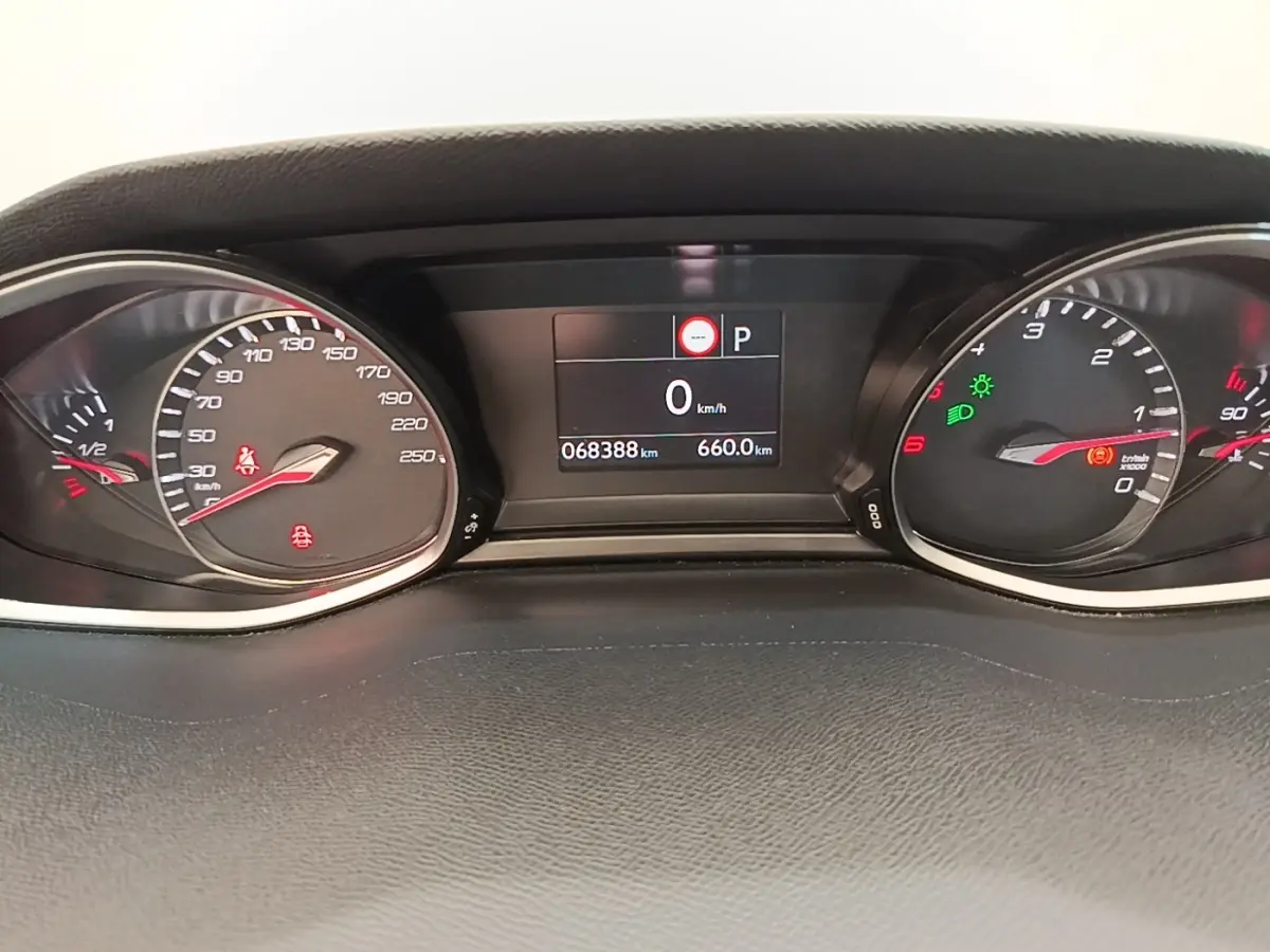 Vue rapprochée du tableau de bord numérique de la Peugeot 308 blanc, affichant 0 km/h et 68 388 km au compteur.