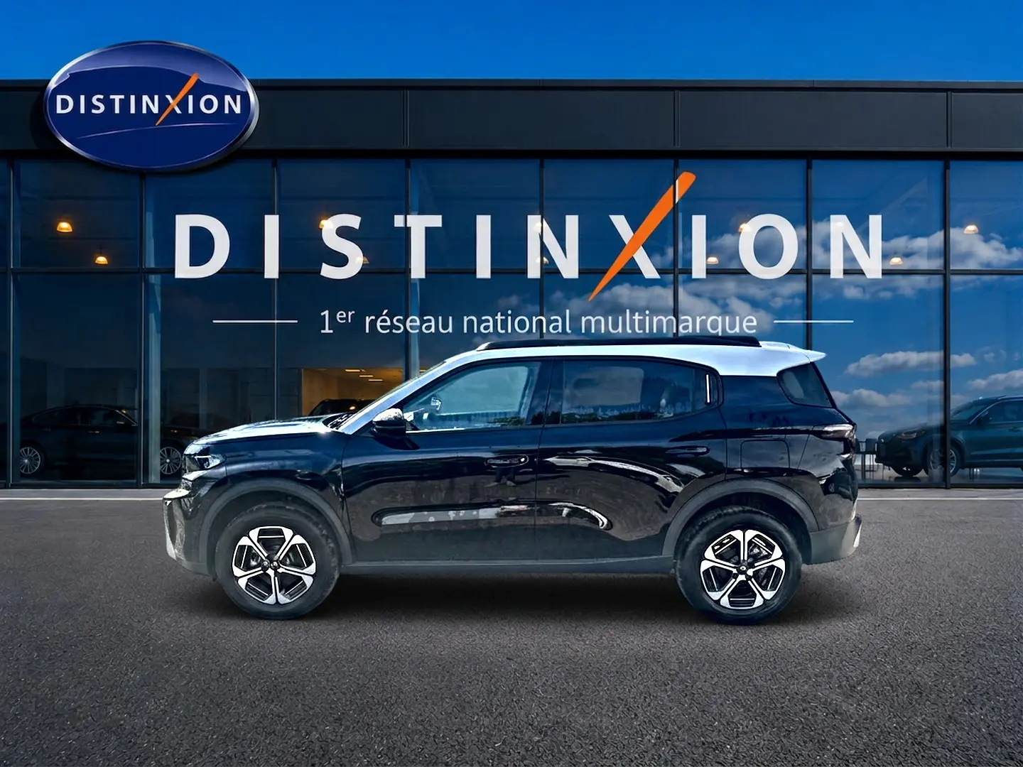 Profil côté gauche d'un Citroën C3 Aircross noir 2026, avec jantes alu et toit blanc devant une vitrine Distinxion.
