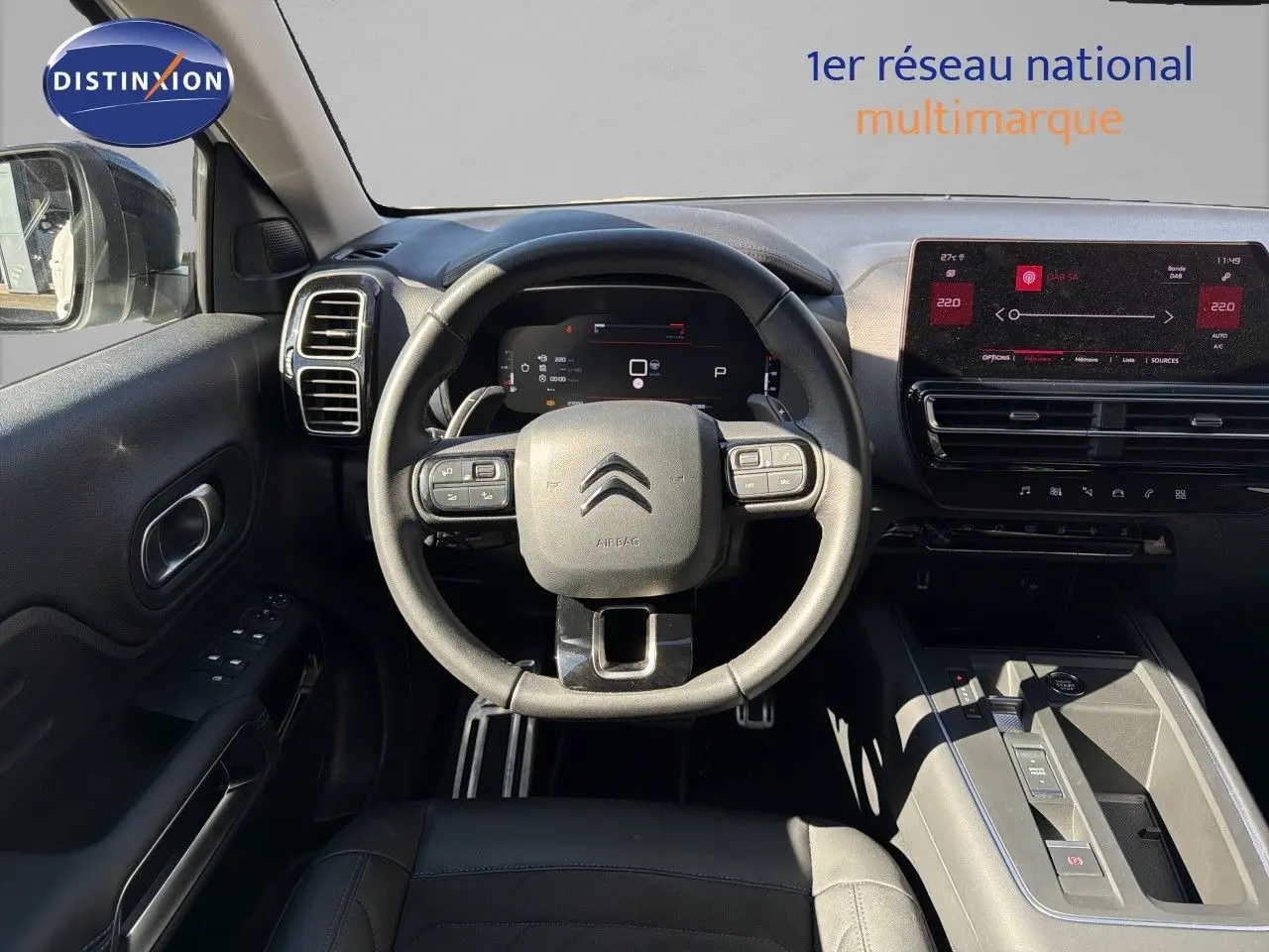 Vue intérieure centrée sur le volant et le tableau de bord du Citroën C5 Aircross blanc nacré 2023, avec écran tactile.