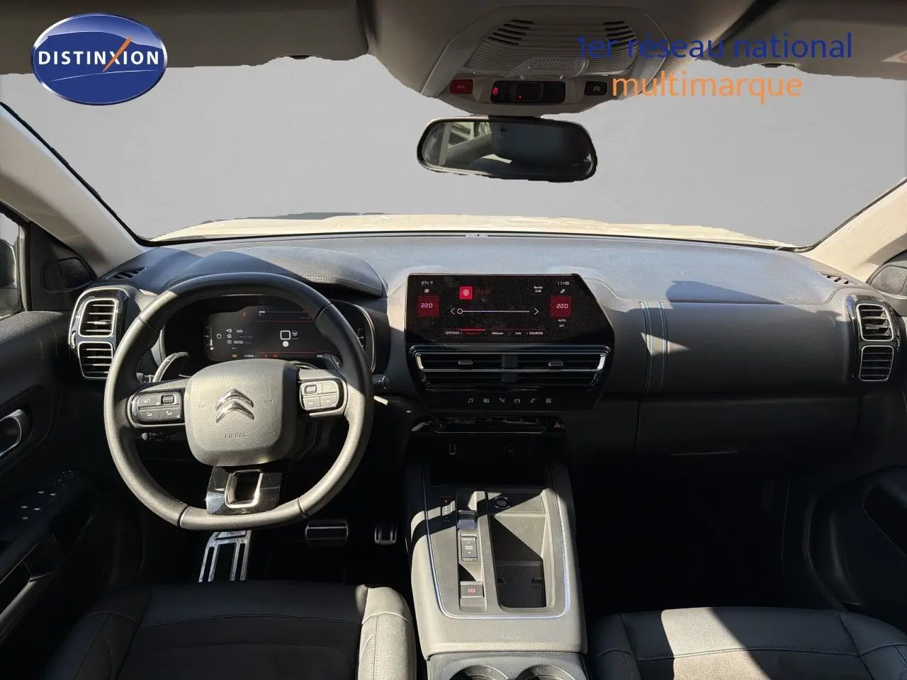 Vue intérieure avant du tableau de bord noir du Citroën C5 Aircross 2023 avec écran tactile et volant multifonction.