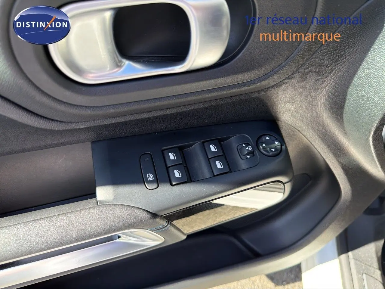 Gros plan sur la commande des vitres et rétroviseurs côté gauche de la porte d’une Citroën C5 Aircross blanche nacrée.