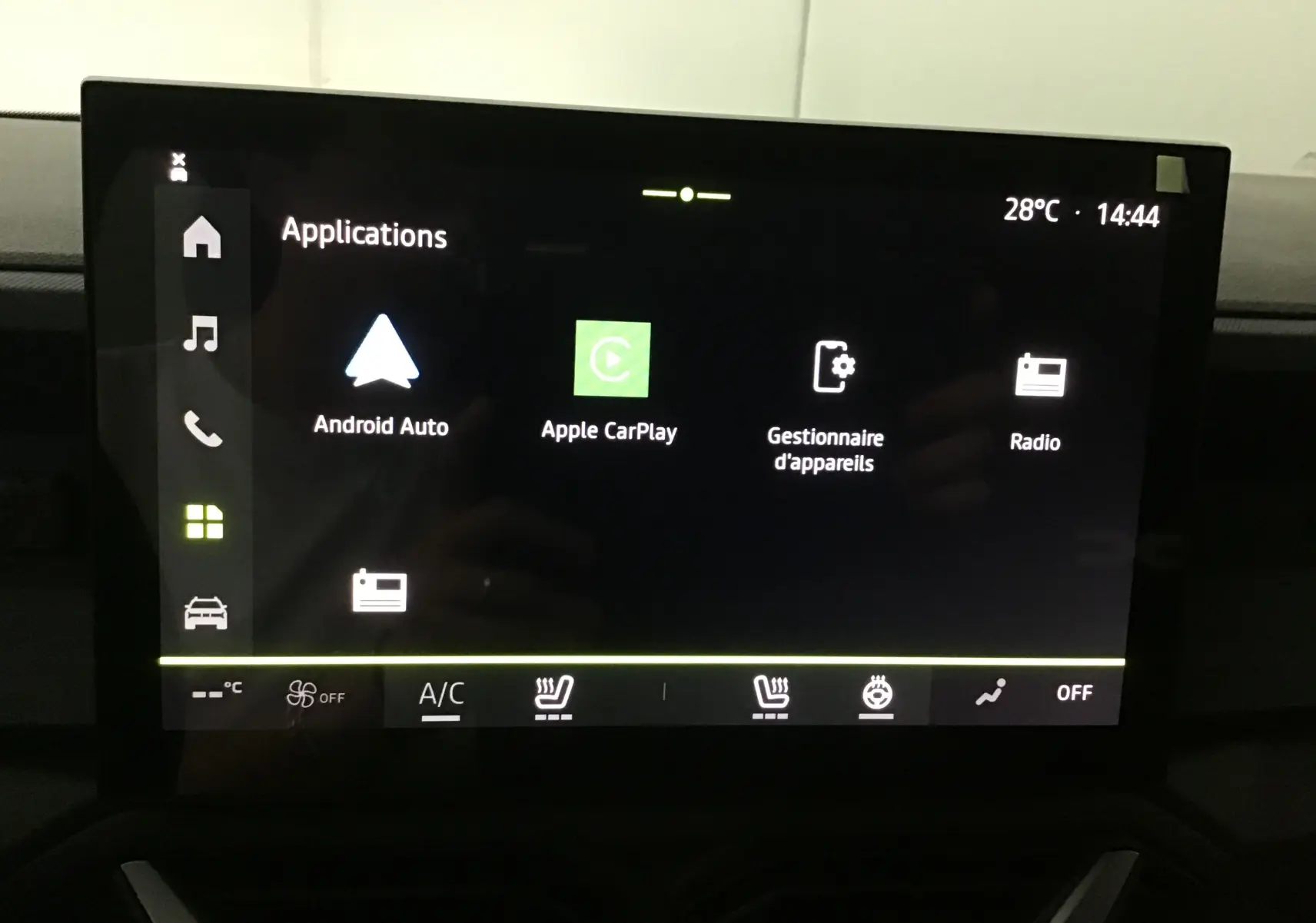 Écran tactile central du Dacia Duster 2025 affichant les applications Android Auto, Apple CarPlay et radio, avec commandes climatisation visibles.
