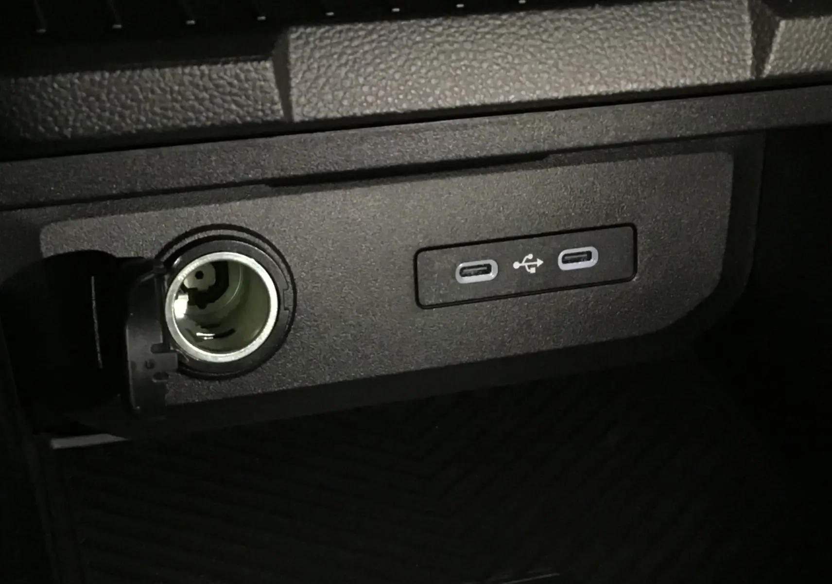 Prise allume-cigare ouverte et deux ports USB-C intégrés dans la console centrale du Dacia Duster 2025.