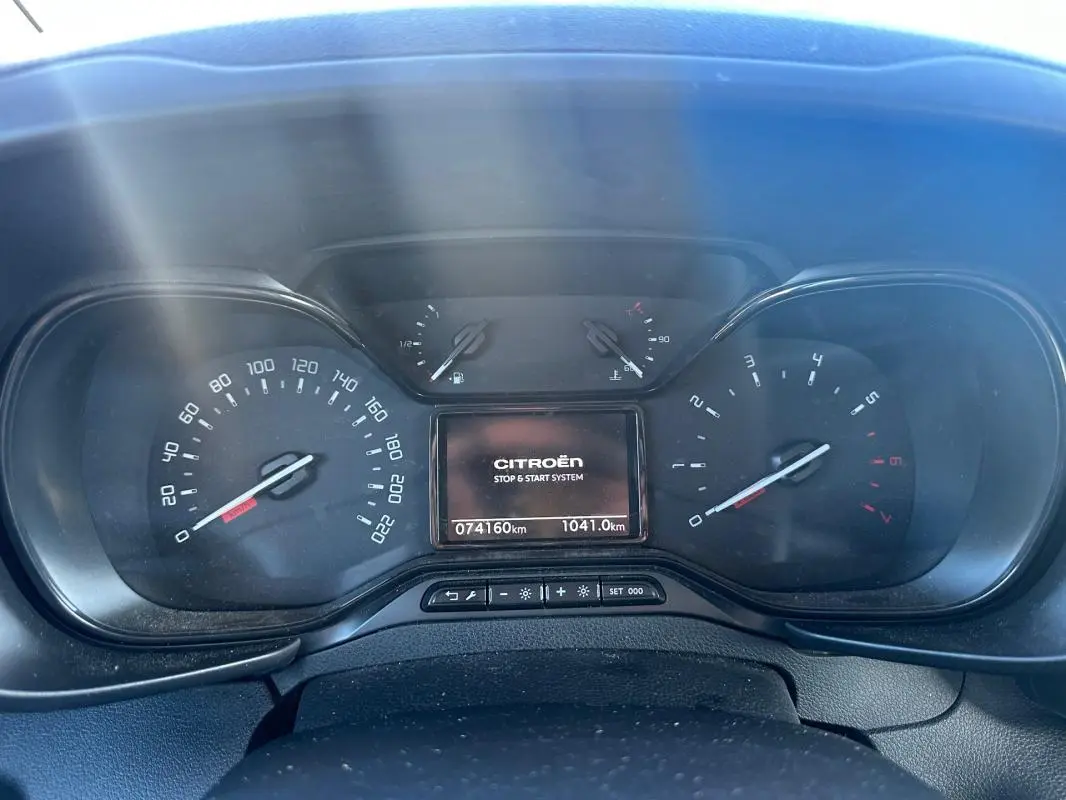 Vue rapprochée du tableau de bord du Citroën Berlingo gris clair 2020, affichant compteurs et écran central digital.