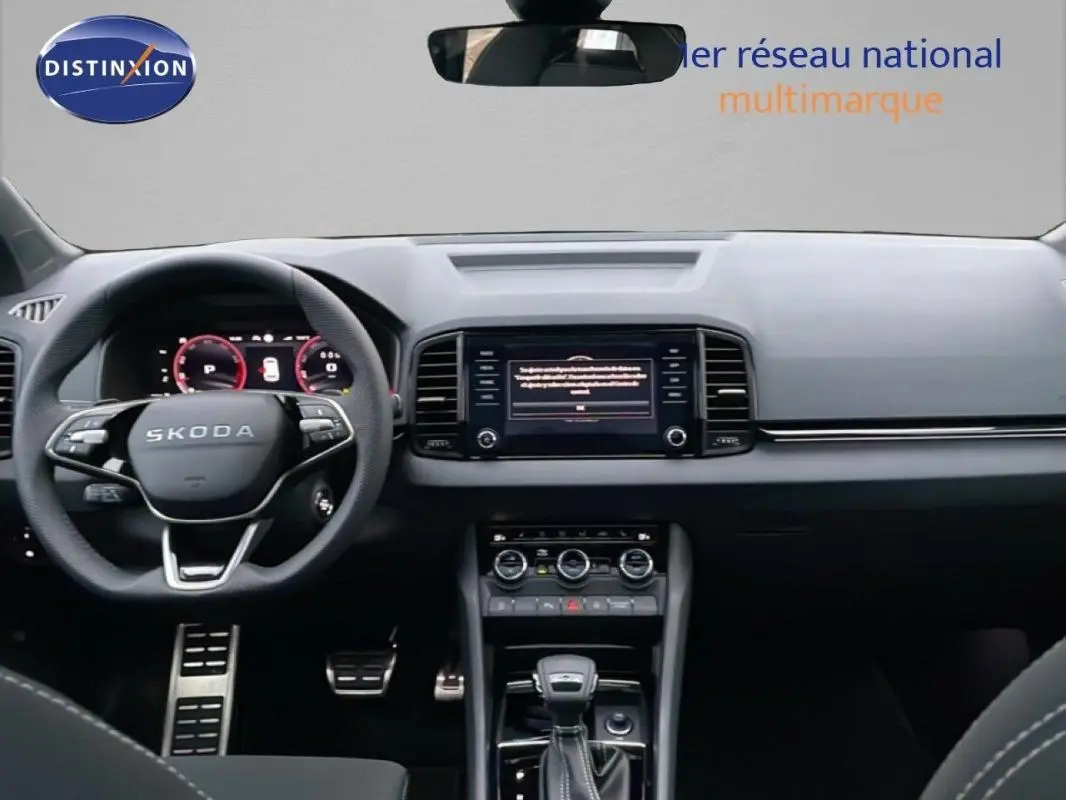 Intérieur noir du Skoda Karoq 2025, vue frontale du tableau de bord avec écran tactile et volant multifonctions.