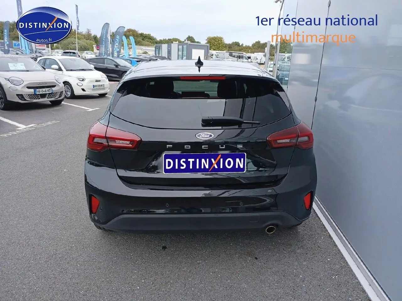 Vue arrière d'une Ford Focus noire Agate métallisé garée près d'un mur, avec feux arrière LED visibles.