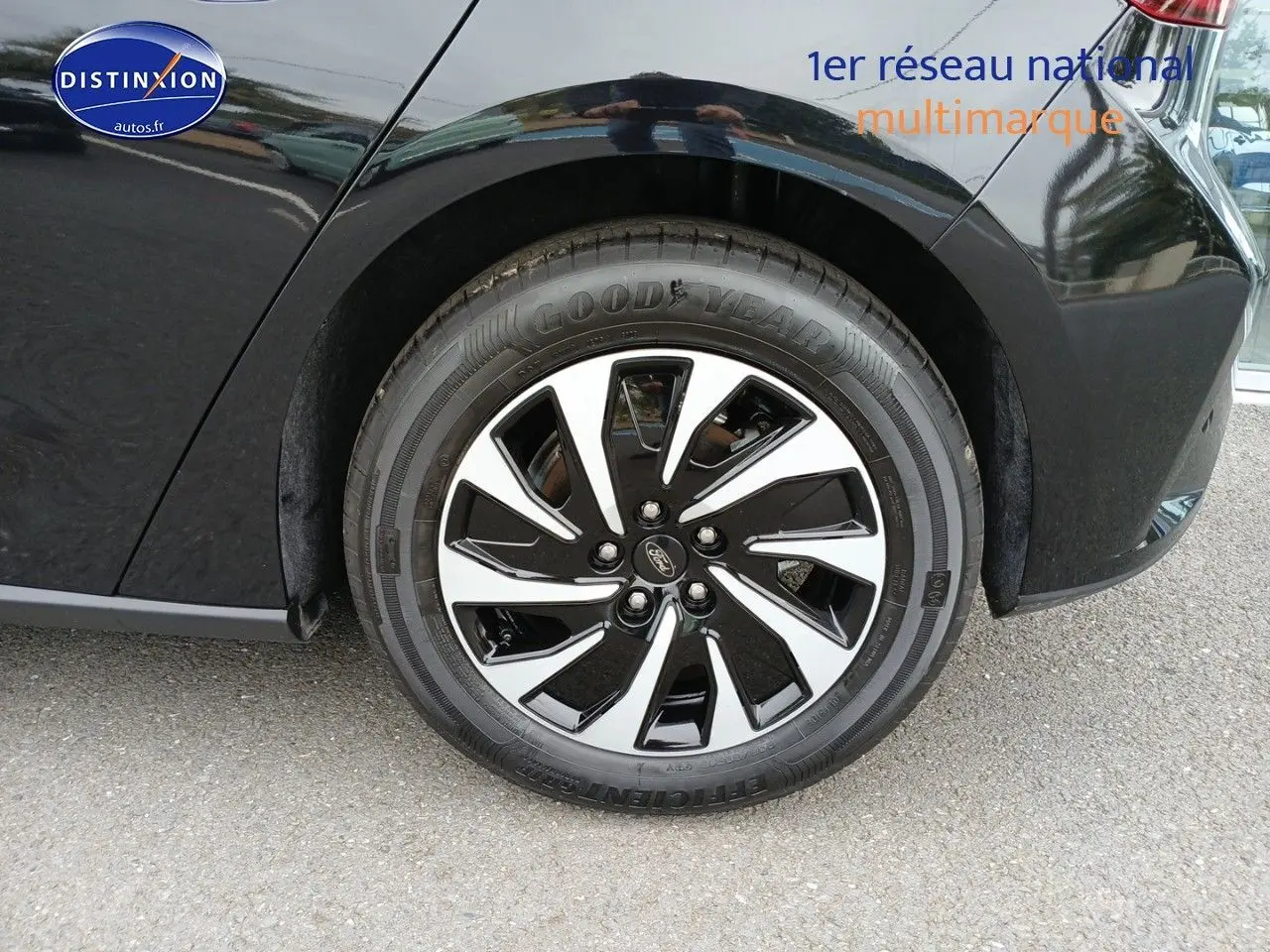 Gros plan sur la roue avant droite noire avec jante alliage bicolore d'une Ford Focus noir Agate métallisé.