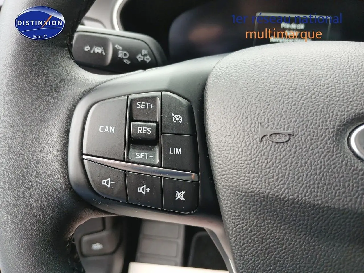 Gros plan sur les commandes multifonctions à gauche du volant cuir de la Ford Focus 2024 noir Agate métallisé.