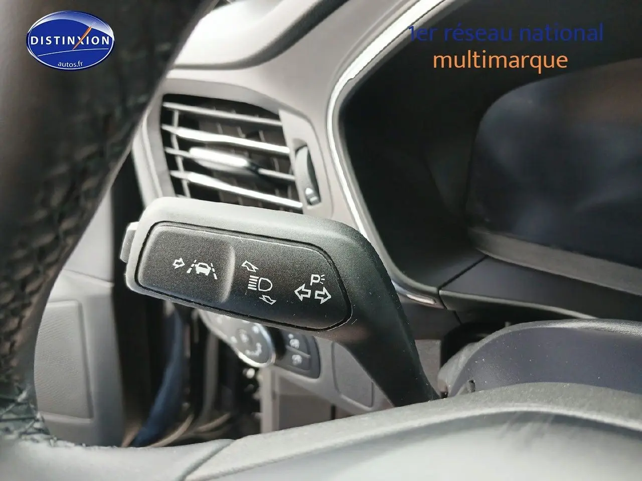 Gros plan sur la commande de clignotants et aides à la conduite dans l’habitacle d’une Ford Focus noire.