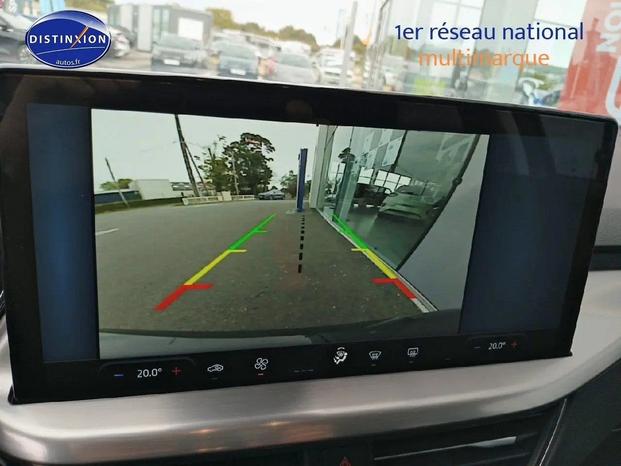 Écran tactile montrant la caméra de recul d'une Ford Focus noire, vue arrière avec lignes de guidage colorées.