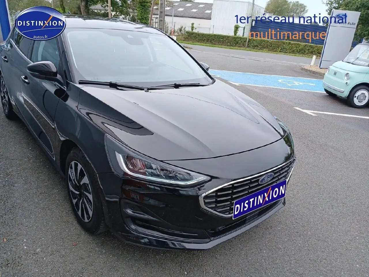 Ford Focus noir Agate métallisé vue 3/4 avant droit avec calandre chromée et phares LED.