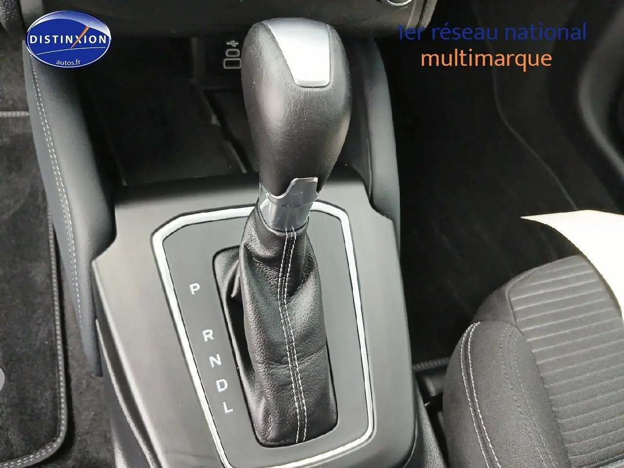 Le levier de vitesse en cuir noir de la Ford Focus 2024, vu en gros plan depuis l'intérieur.