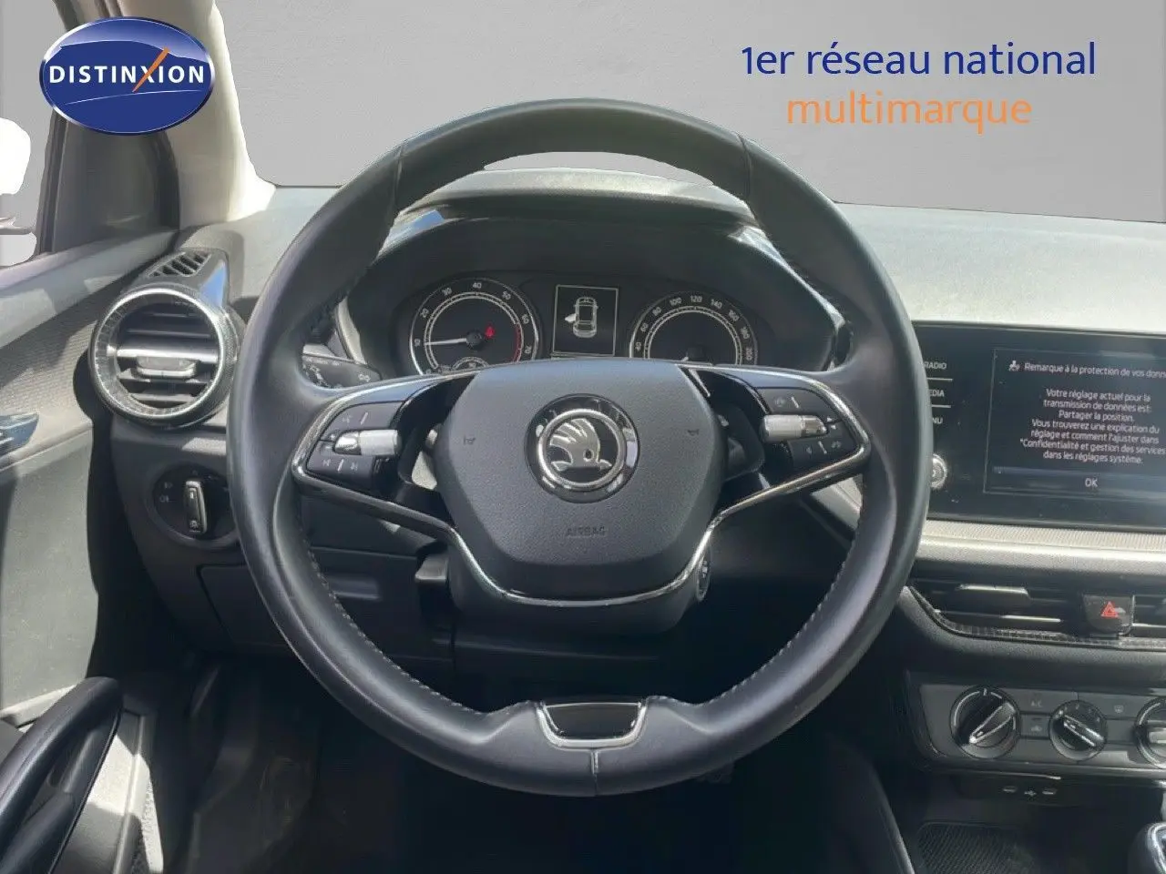 Vue intérieure centrée sur le volant cuir noir de la Skoda Fabia 2022 avec tableau de bord et écran multimédia visibles.
