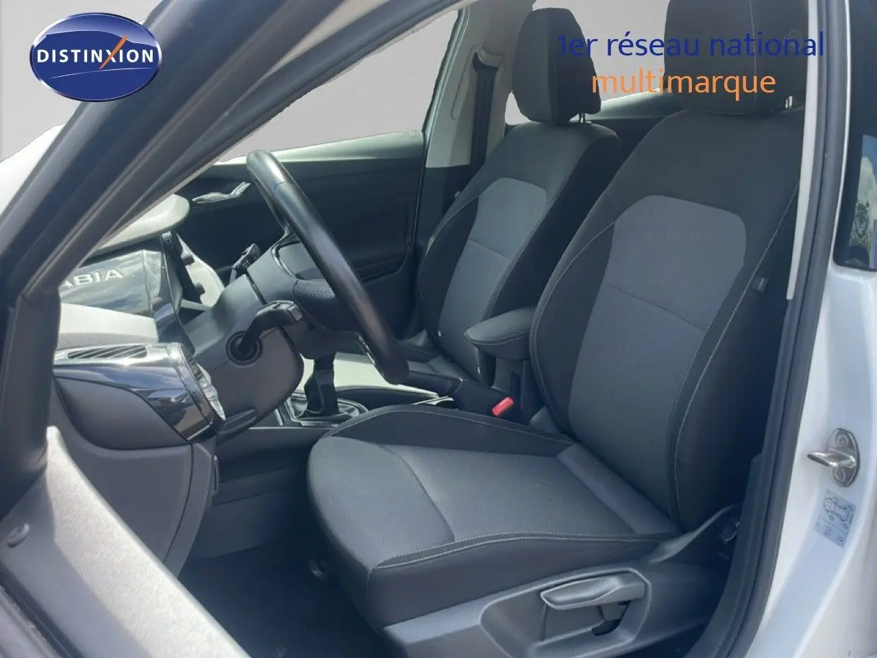 Intérieur côté conducteur d'une Skoda Fabia blanche 2022, sièges tissu noir et gris, volant cuir multifonction.