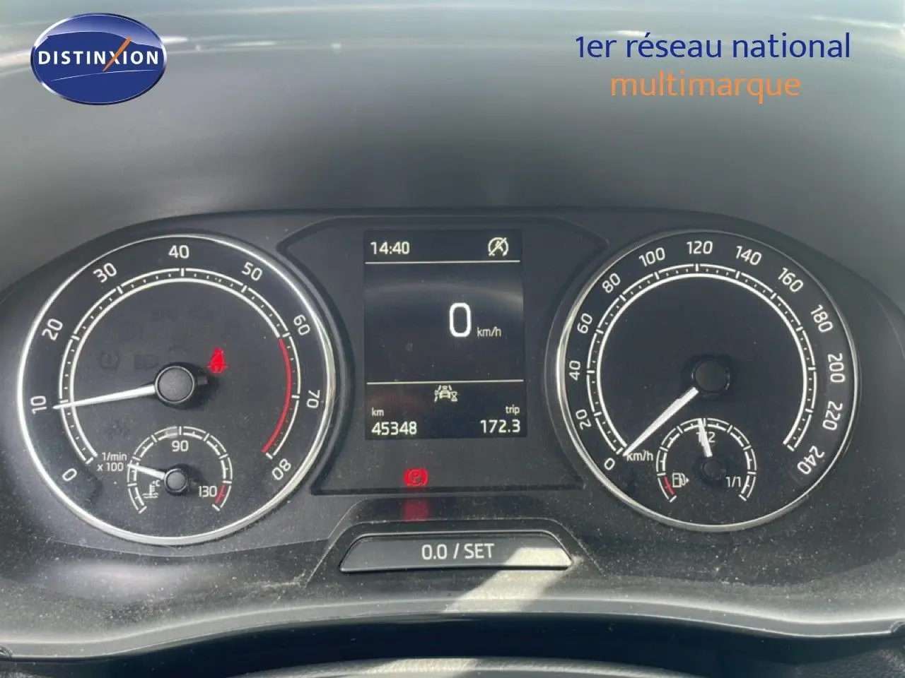 Vue rapprochée du tableau de bord de la Skoda Fabia blanc candy, affichant compteur et écran digital à l'arrêt.