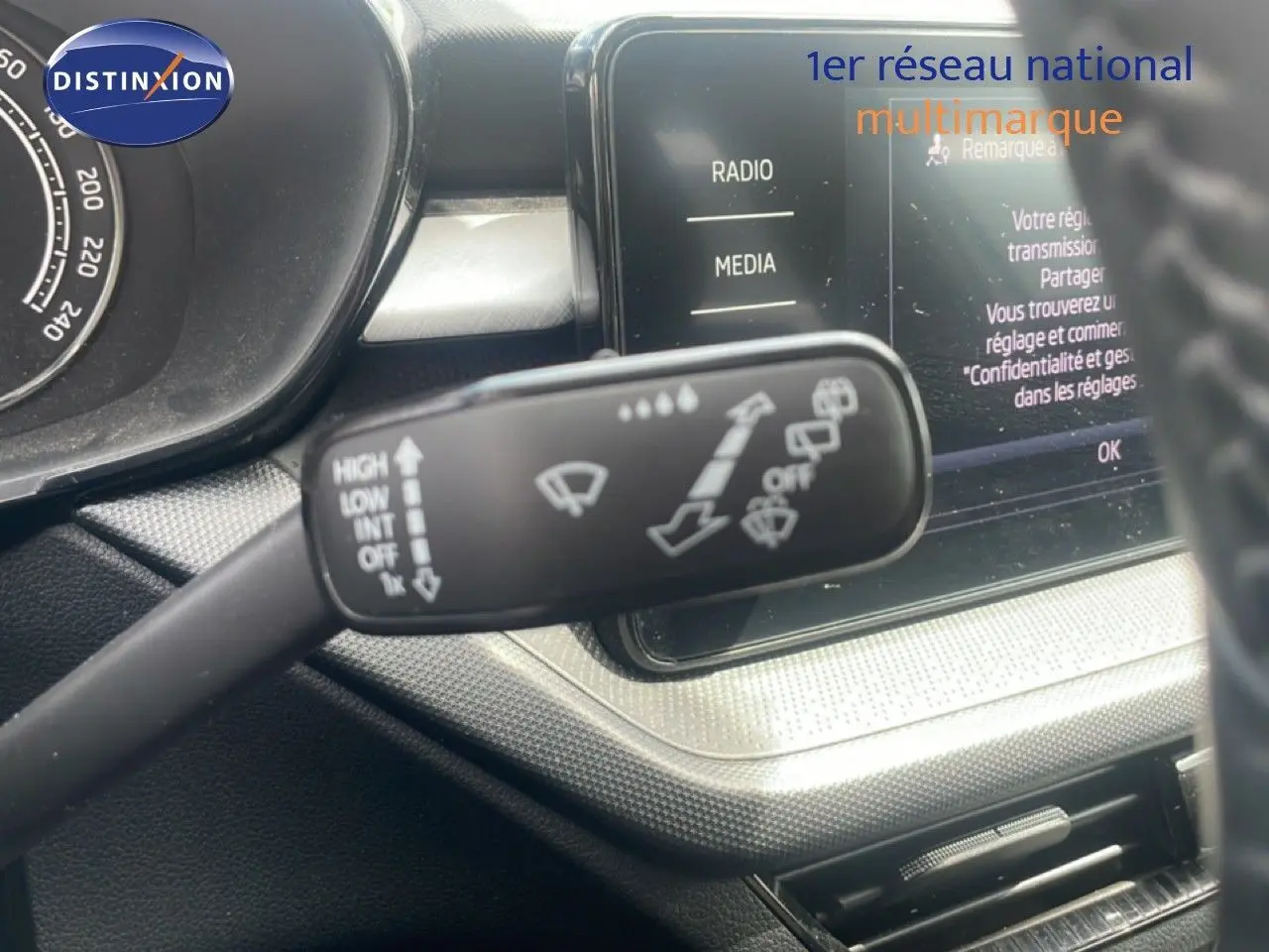 Gros plan sur la commande d’essuie-glace à gauche du volant dans l’habitacle d’une Skoda Fabia blanche 2022.