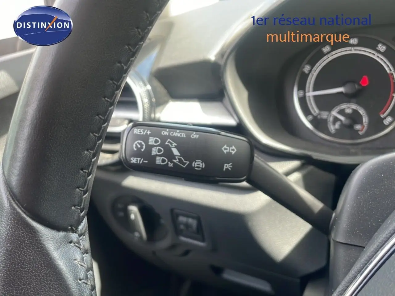 Gros plan sur le commodo gauche du volant d’une Skoda Fabia 2022, intérieur noir avec tableau de bord visible.
