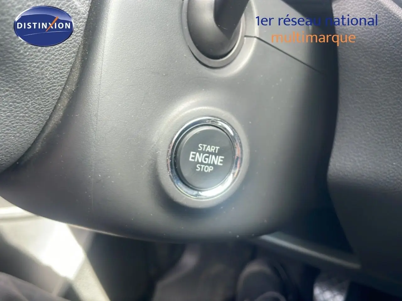 Gros plan sur le bouton Start Engine Stop noir entouré de chrome dans l'habitacle d'une Skoda Fabia blanche.