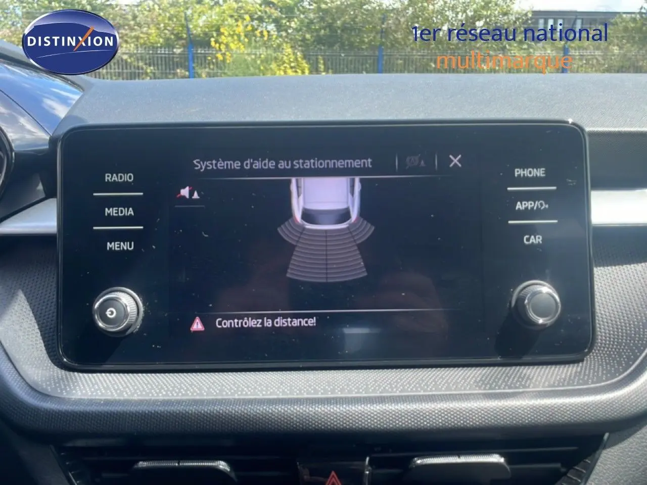 Écran tactile central du système d’aide au stationnement dans une Skoda Fabia blanche, vue intérieure frontale.