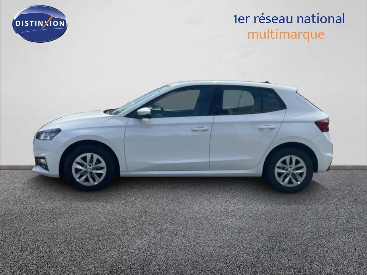 Profil droit d'une Skoda Fabia blanche Candy 2022, compacte et moderne, sur fond neutre intérieur showroom.