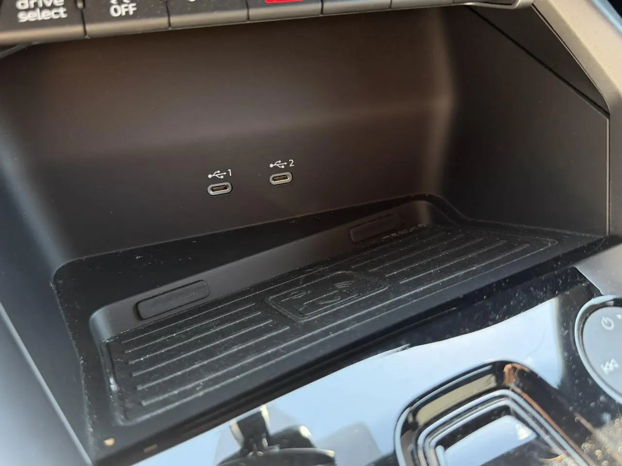 Détail de la console centrale noire de l'Audi A3 Sportback 2025 avec deux ports USB-C et zone de recharge sans fil.
