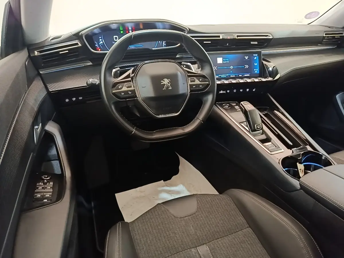 Vue intérieure avant du tableau de bord et volant cuir noir de la Peugeot 508 Puretech 2019 avec écran tactile central.