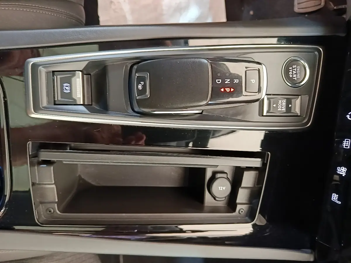 Gros plan sur la console centrale noire de la Peugeot 508 avec levier de vitesse automatique et bouton start/stop.