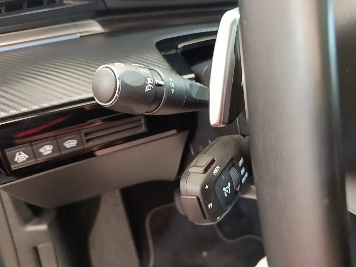 Gros plan sur la commande multifonction et la manette d’essuie-glace du tableau de bord intérieur d’une Peugeot 508 gris foncé.