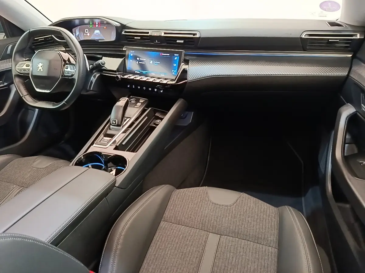 Vue intérieure avant droite du Peugeot 508 gris foncé, avec tableau de bord numérique et écran tactile central lumineux.