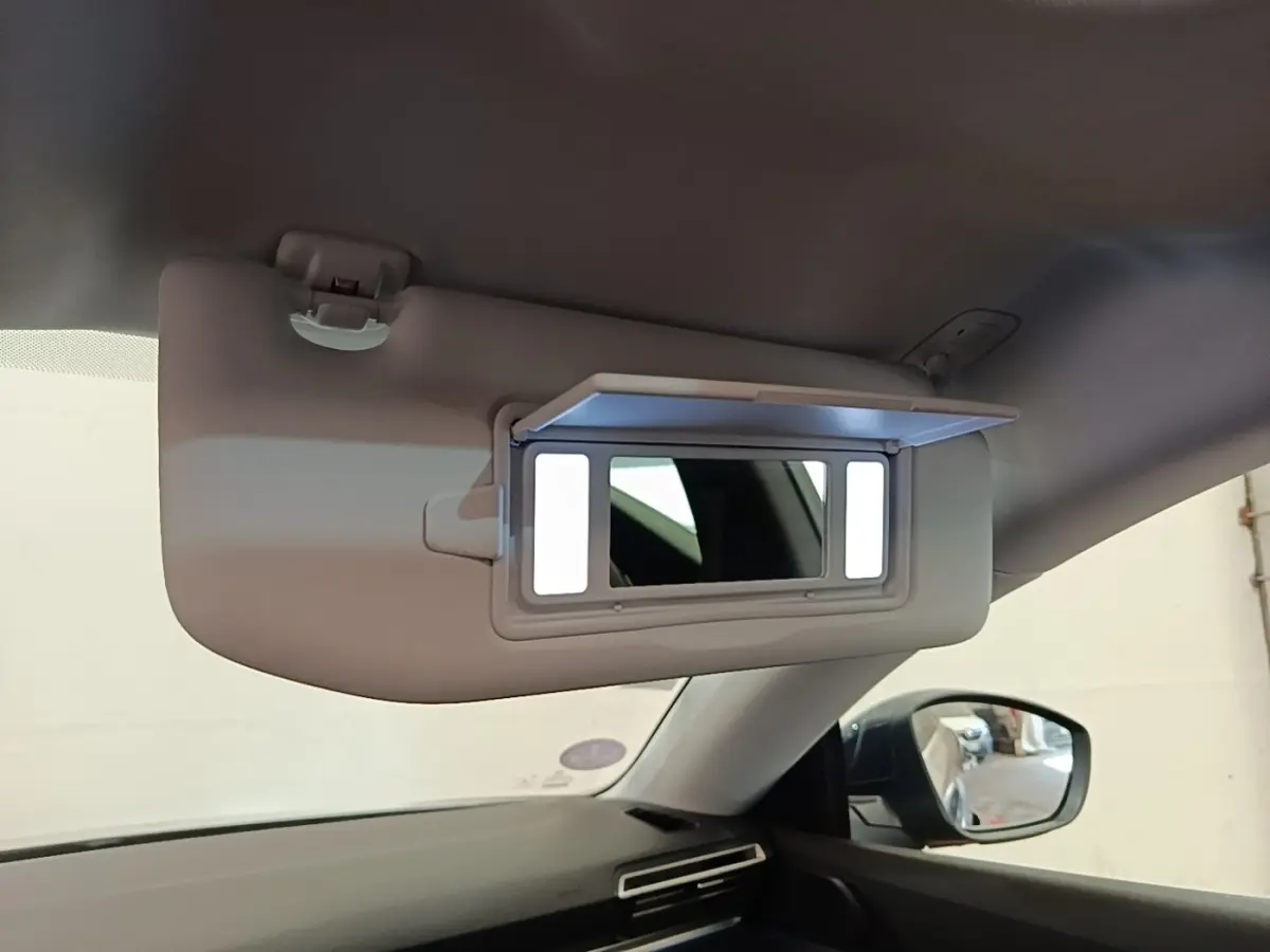 Détail du pare-soleil avec miroir éclairé à l'intérieur d'une Peugeot 508 gris foncé, vue côté conducteur.