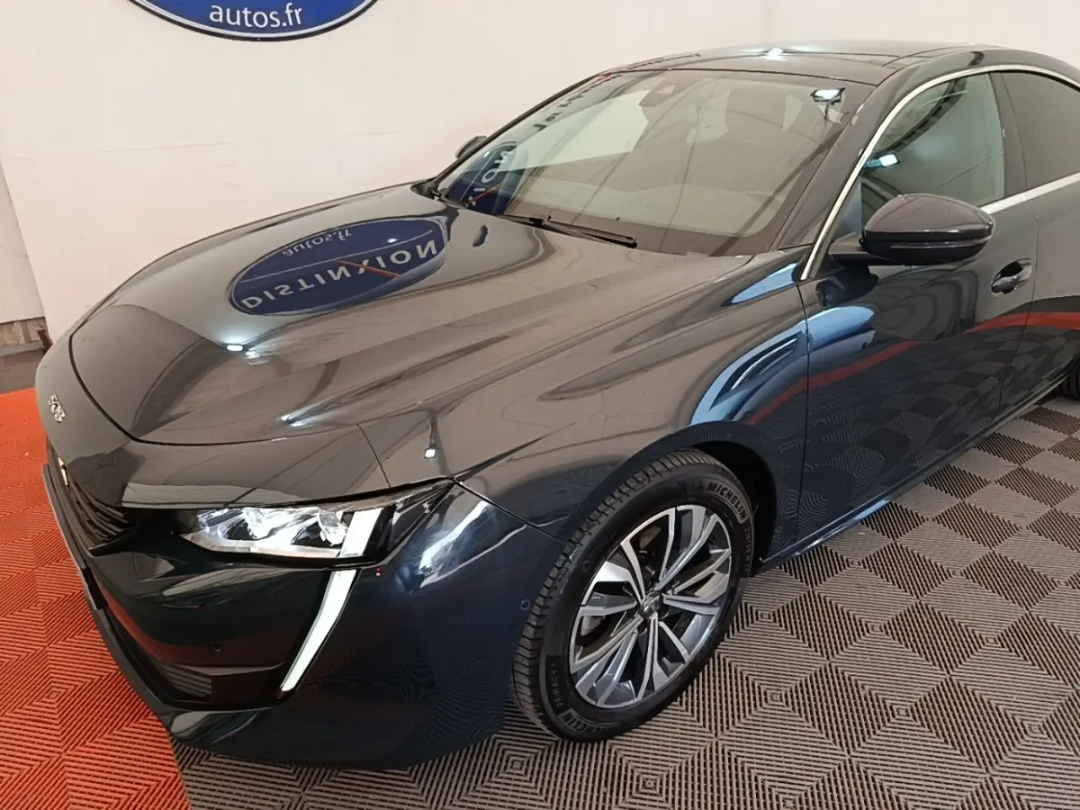Peugeot 508 gris foncé vue 3/4 avant droit, avec phares LED et jantes alliage distinctives.