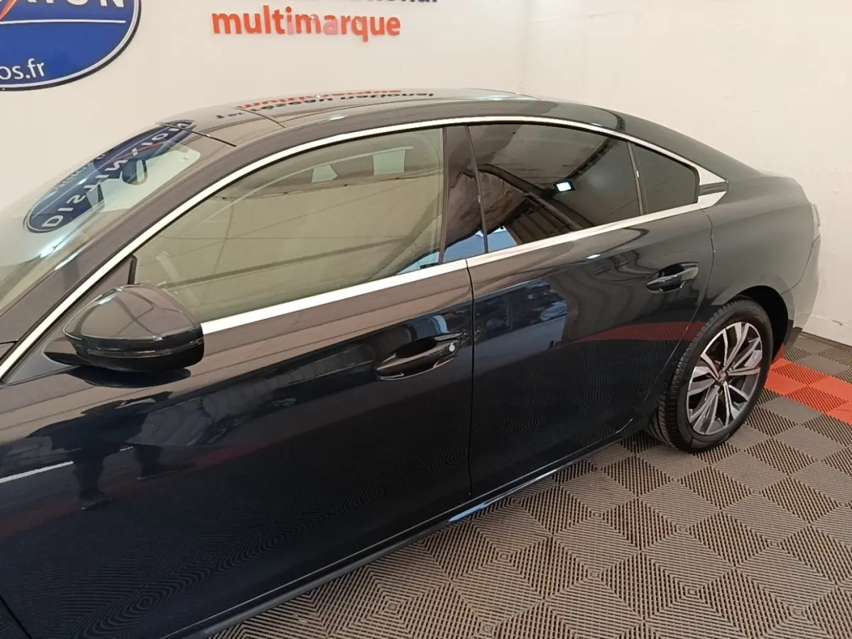 Profil droit de la Peugeot 508 gris foncé, mettant en valeur les jantes alliage et les vitres teintées.