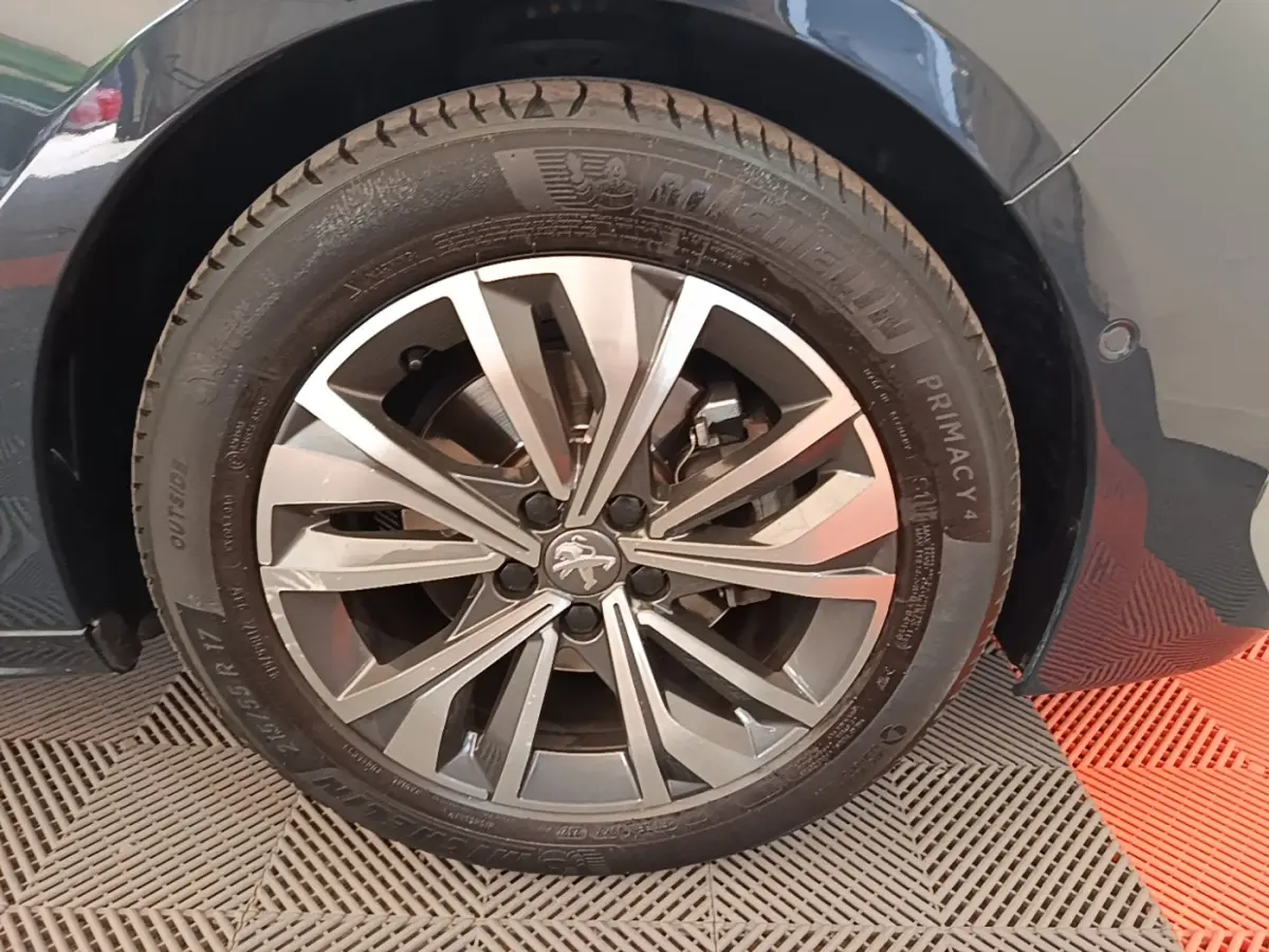 Gros plan sur la roue avant droite gris foncé d'une Peugeot 508 avec jante alliage à motifs en étoile.