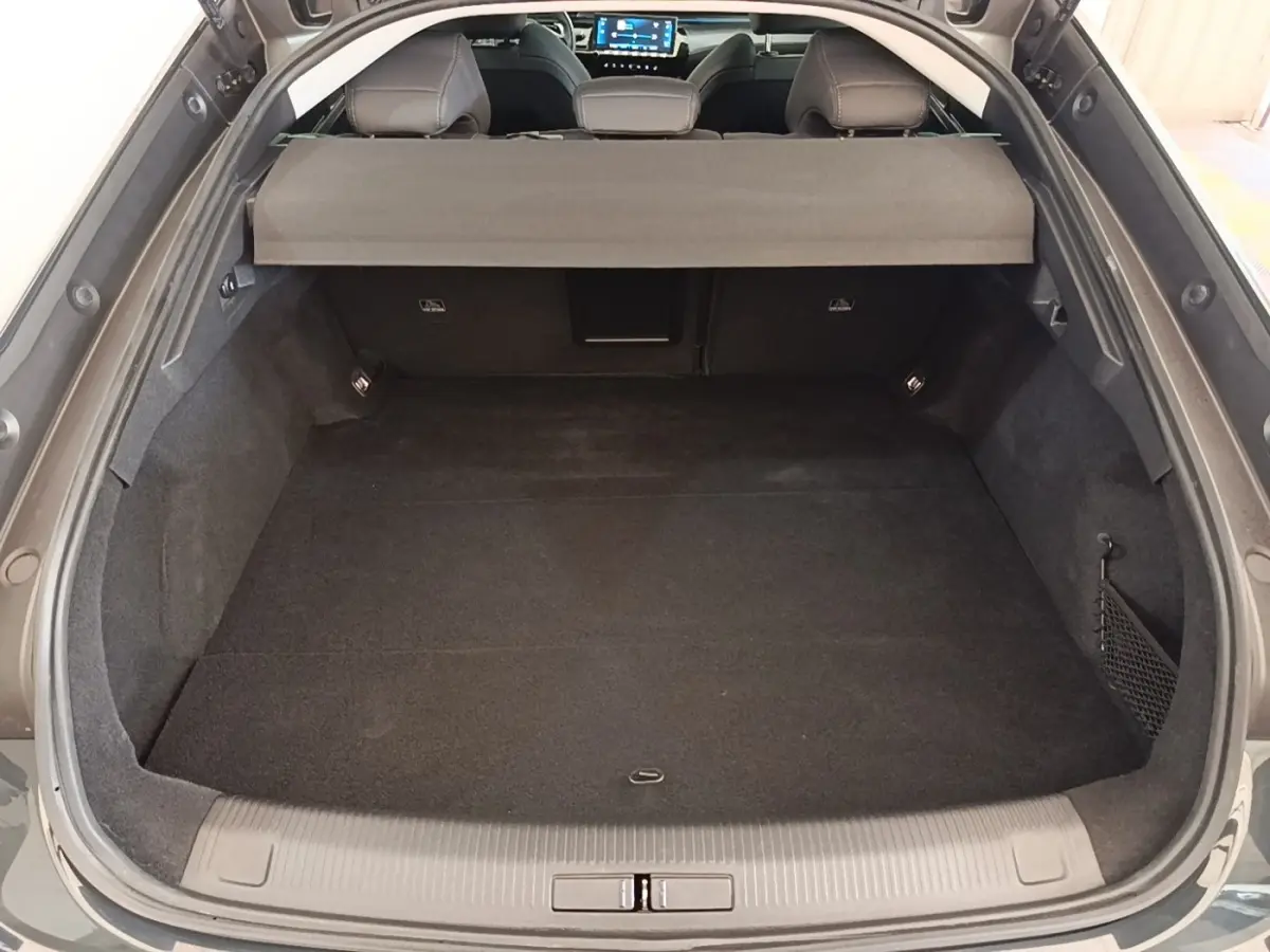 Coffre ouvert vu de l'arrière d'une Peugeot 508 gris foncé avec banquette arrière et cache-bagages visibles.