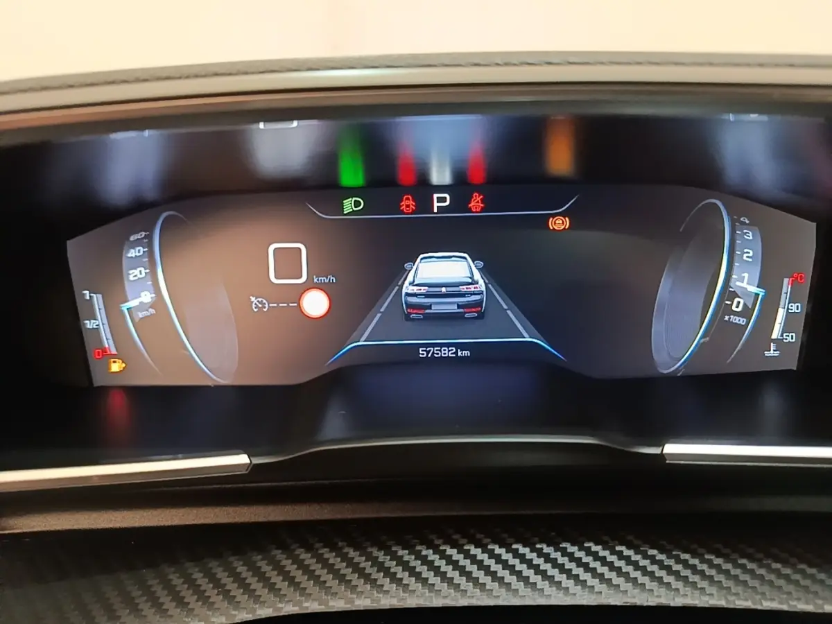 Affichage numérique du tableau de bord de la Peugeot 508 gris foncé, montrant la vue arrière du véhicule et les indicateurs de vitesse et régime.