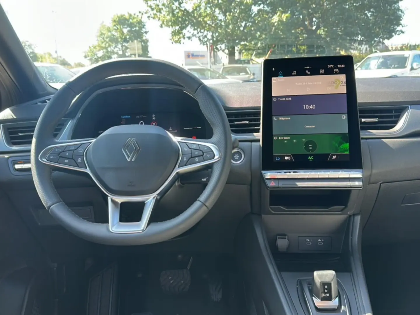 Vue intérieure frontale du tableau de bord et volant Renault Captur gris cassiopée avec écran tactile vertical et levier de boîte automatique.