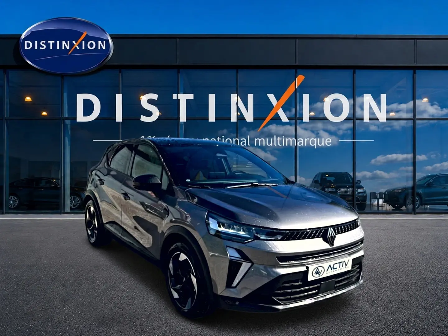 Renault Captur 2026 gris cassiopée en 3/4 avant, avec jantes alu et calandre moderne devant showroom Distinxion.