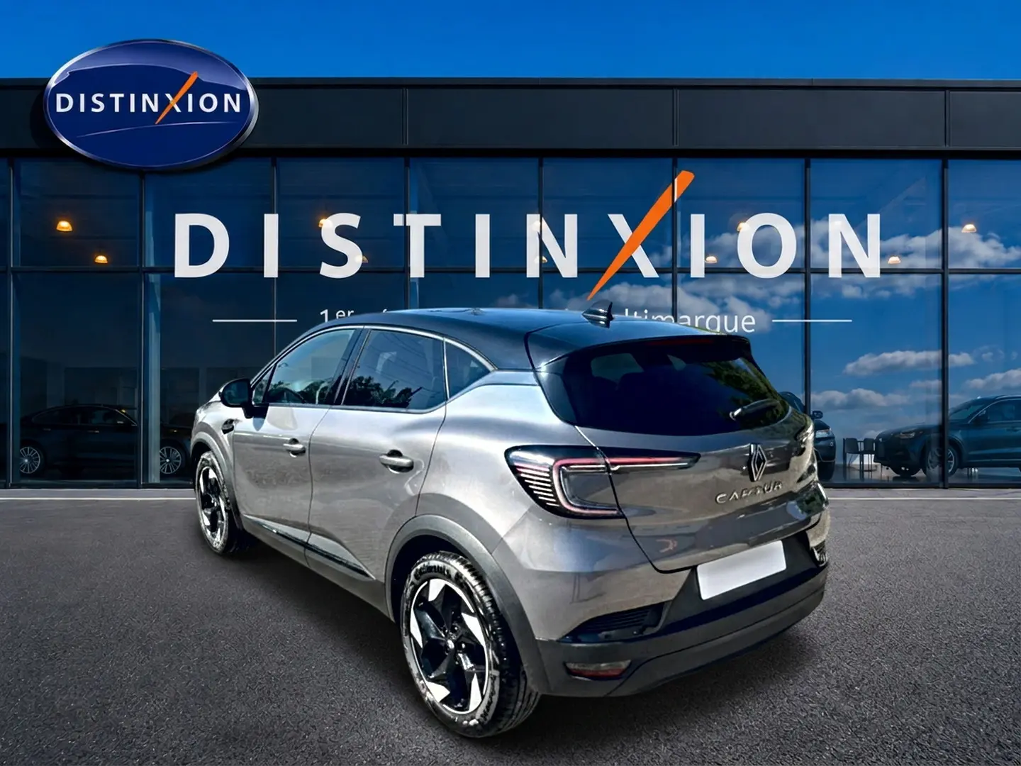 Renault Captur gris cassiopée en 3/4 arrière droit, avec jantes alu noires et toit noir brillant.