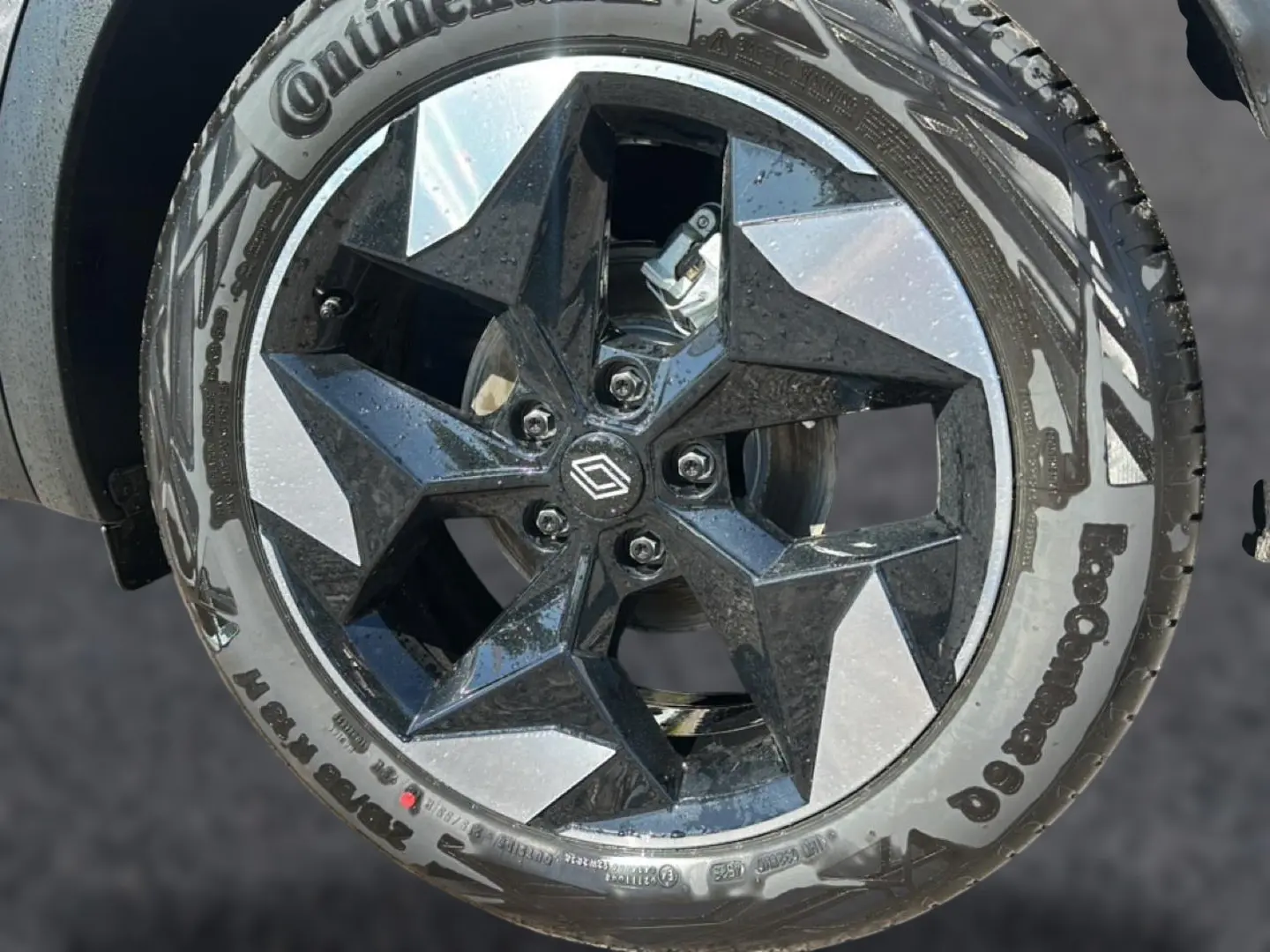 Gros plan sur la jante alu noire et gris argent du Renault Captur 1.8 e-tech full hybrid 160 techno, avec logo Renault central.