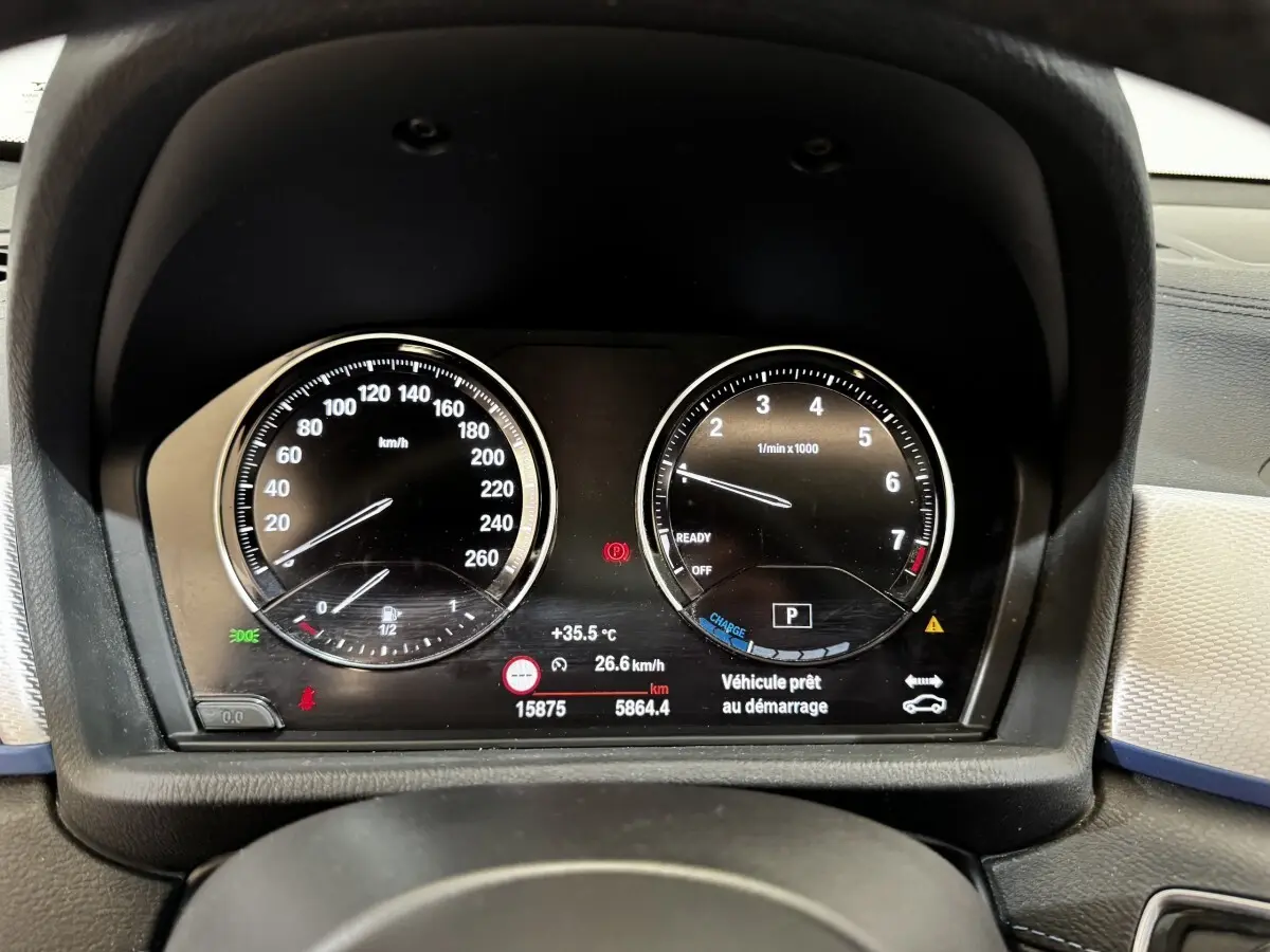 Vue rapprochée du tableau de bord numérique de la BMW X2 blanc, affichant vitesse et compte-tours.