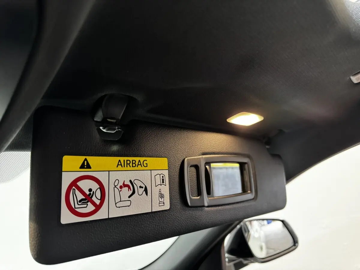 Détail du pare-soleil côté conducteur avec miroir éclairé dans un BMW X2 blanc hybride rechargeable 2022.