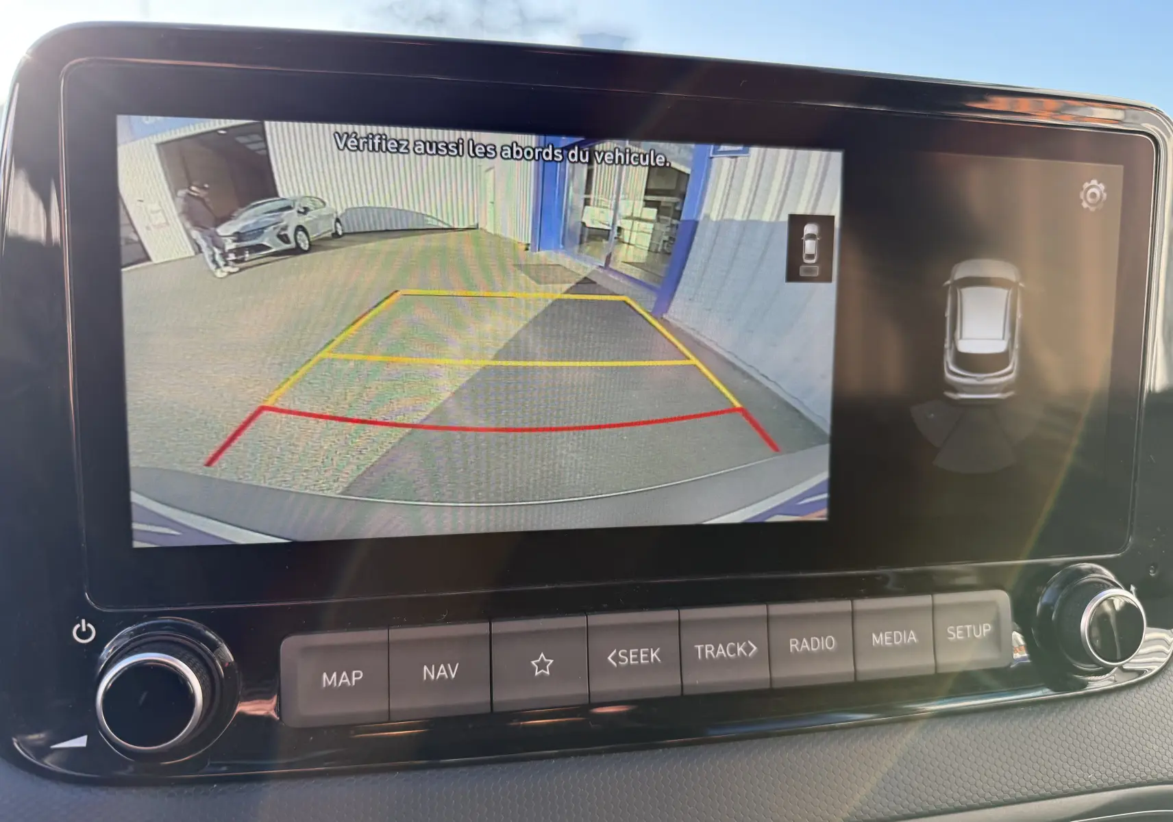 Écran de caméra de recul du Hyundai Kona blanc Atlas 2021 affichant une vue arrière avec lignes de guidage colorées.