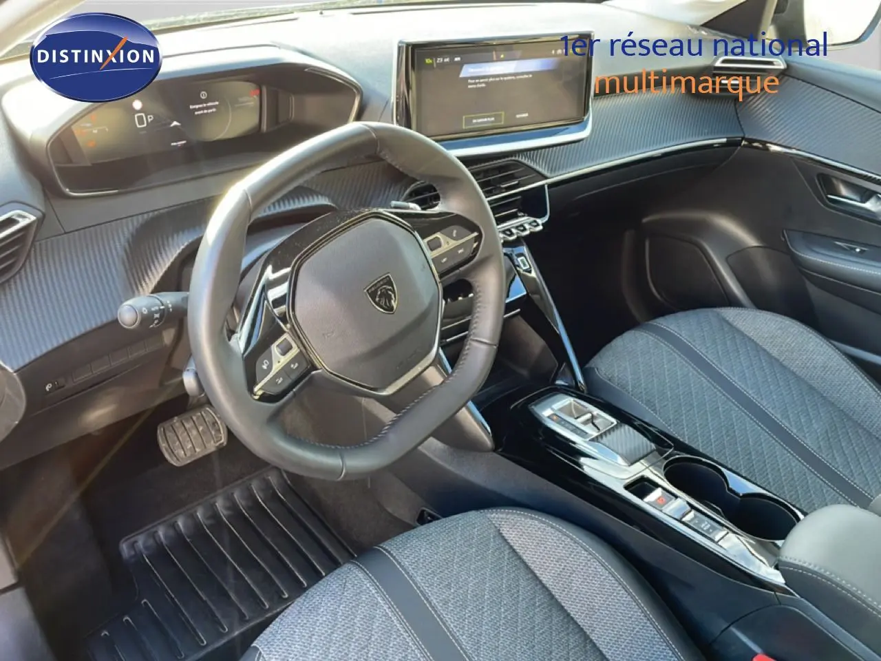 Vue intérieure de la Peugeot 208 noire 2025, tableau de bord et volant multifonctions avec écran tactile central.