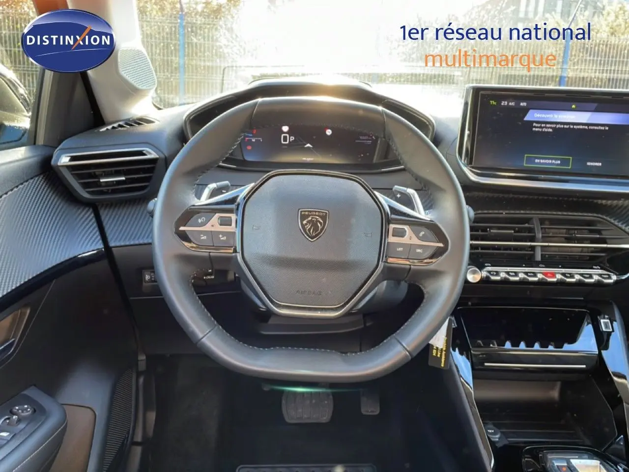 Vue intérieure centrée sur le volant noir de la Peugeot 208 1.2 Hybrid 110ch avec tableau de bord digital et écran tactile.