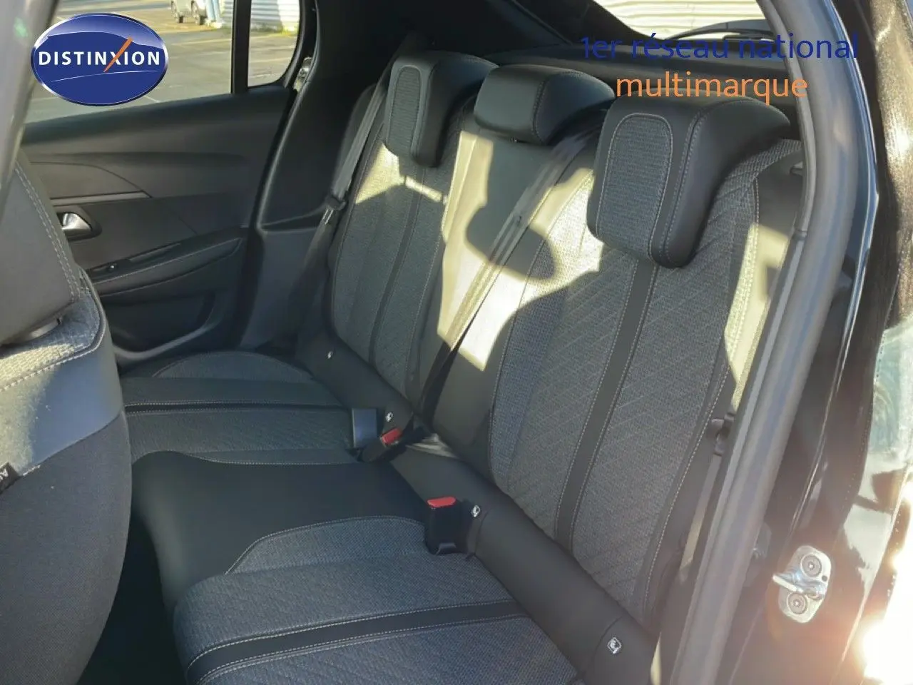 Vue intérieure côté droit des sièges arrière en tissu gris et cuir noir d'une Peugeot 208 noire 2025 hybride.