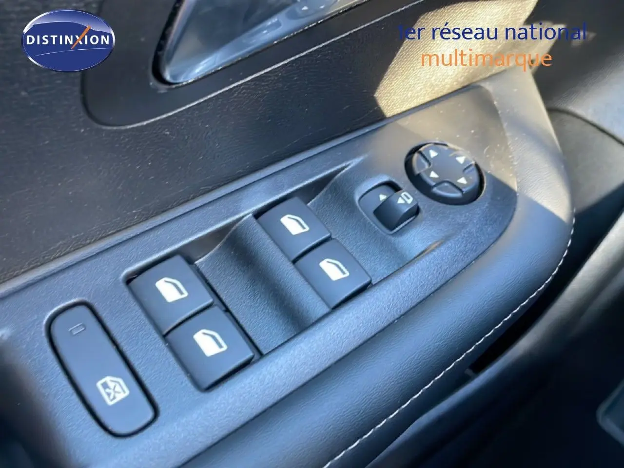 Gros plan sur les commandes de lève-vitres et réglages des rétroviseurs côté conducteur d'une Peugeot 208 noire 2025.