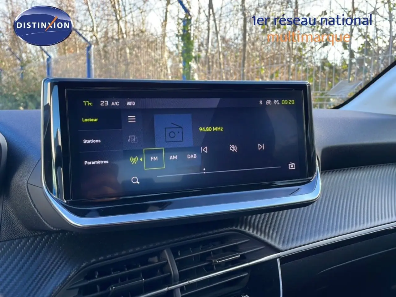 Écran tactile central de la Peugeot 208 noire 2025, vue intérieure du tableau de bord avec affichage radio FM.